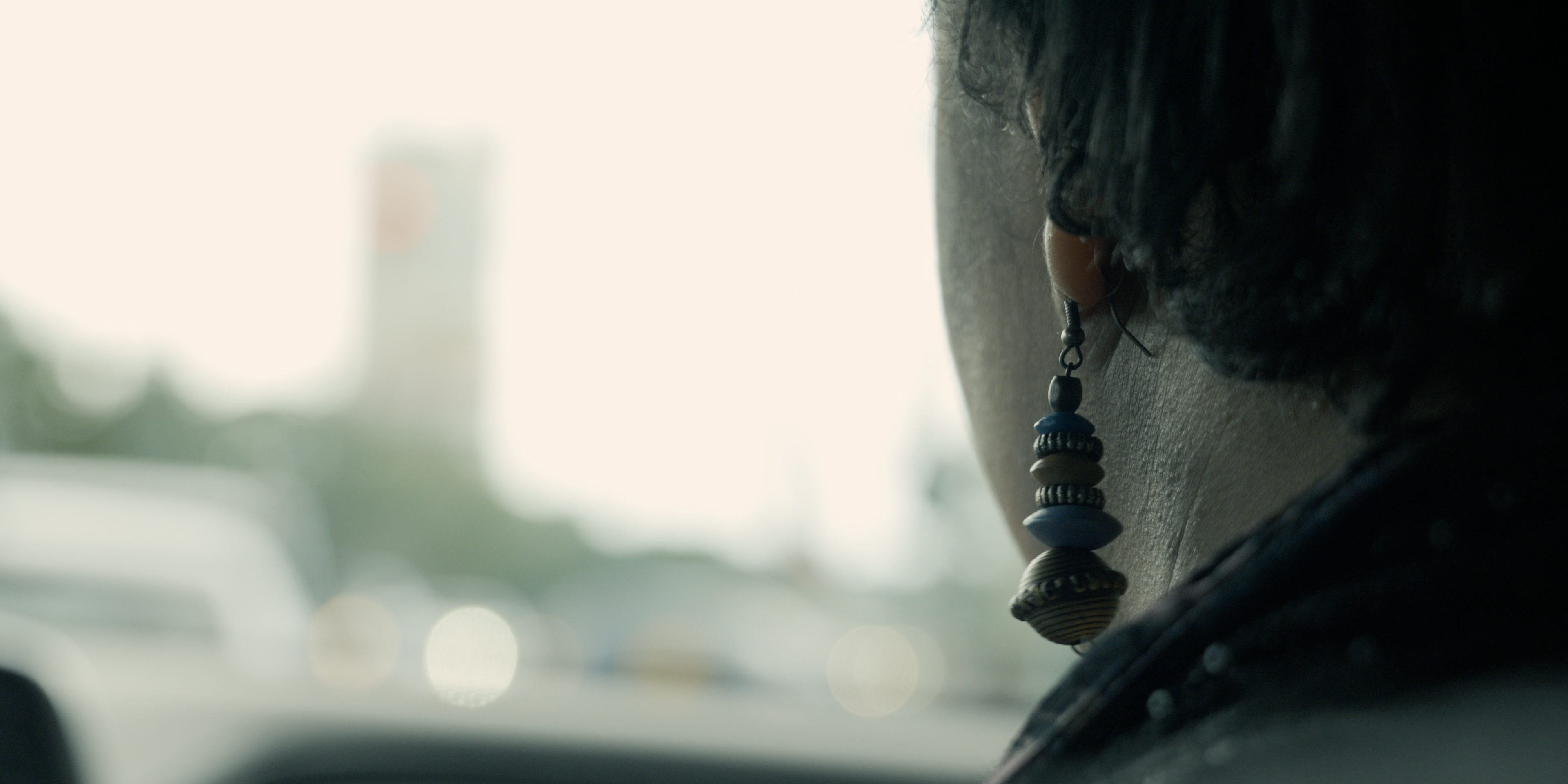 Close-up of a performer's earring while riding in a car in Victoria Ka Raja