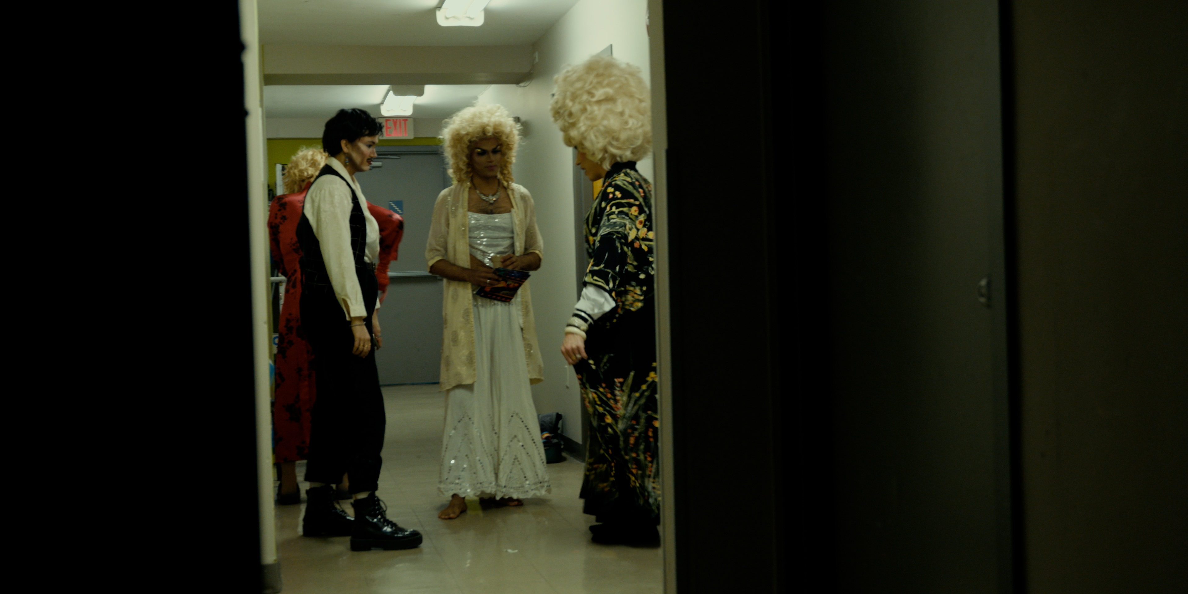Drag performers talking together in a backstage hallway in Victoria Ka Raja
