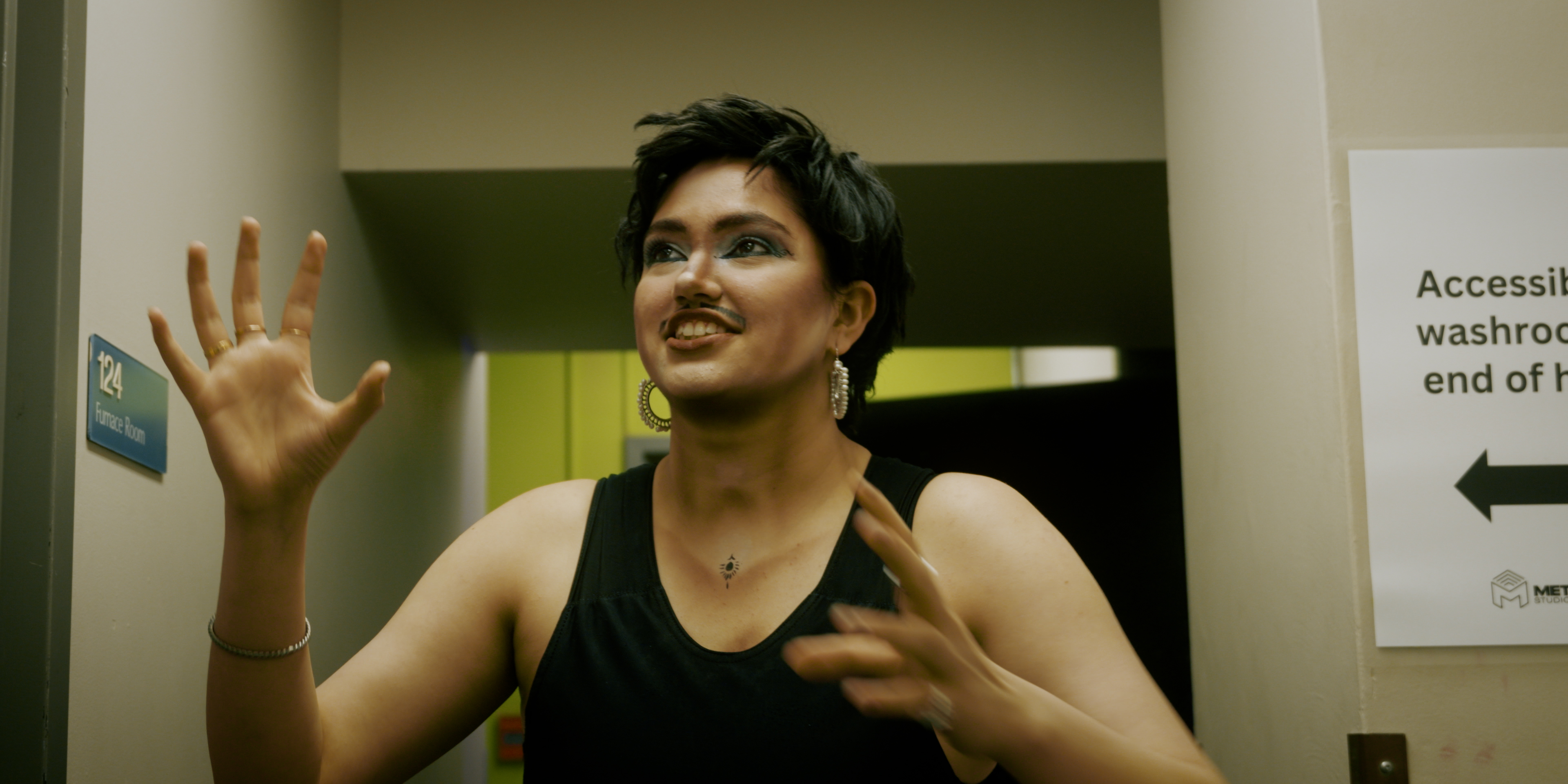Drag king speaking backstage while dressed in performance makeup and moustache in Victoria Ka Raja